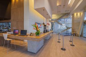 a lobby with a counter with a laptop on it at ibis Cartagena Marbella in Cartagena de Indias