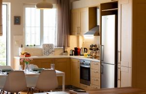 a kitchen with a table and a refrigerator at Athens Airport Lodge in Spáta