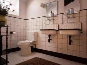 ein Badezimmer mit zwei Waschbecken und einer Toilette in der Unterkunft The Riverhouse, magical house with garden by the river Seine in Gyé-sur-Seine