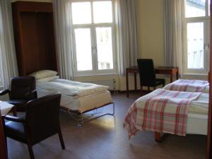 um quarto com duas camas e cadeiras e janelas em Hotel Continental Malmö em Malmo