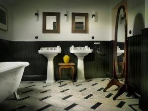 ein Badezimmer mit zwei Waschbecken und einem Spiegel in der Unterkunft The Riverhouse, magical house with garden by the river Seine in Gyé-sur-Seine