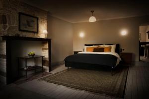 ein Schlafzimmer mit einem Bett und einem Kamin in der Unterkunft The Riverhouse, magical house with garden by the river Seine in Gyé-sur-Seine