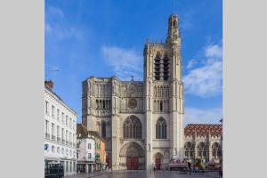 a large church with a tower on a street at L’Industriel in Sens