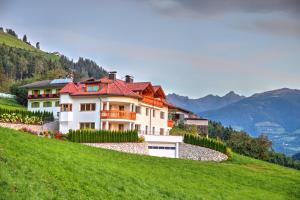 uma casa ao lado de uma colina verde em Hof Unterguggenberg em San Lorenzo di Sebato