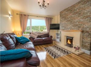 a living room with a couch and a fireplace at Hillview Holiday Home in Clonmany