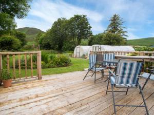 a deck with two chairs and a table on it at Hillview Holiday Home in Clonmany