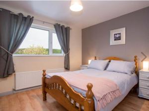 a bedroom with a large bed and a window at Hillview Holiday Home in Clonmany