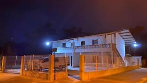 a white house with a gate in front of it at night at RESIDENCE APPARTEMEN'T in Sinnamary