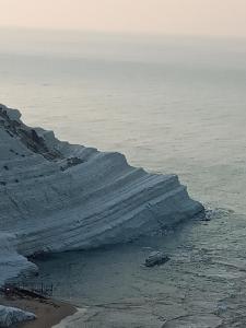 um iceberg no oceano ao lado de uma praia em Villa Scavuzzo em Realmonte