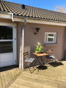 een patio met een tafel en stoelen op een huis bij Hartel House in Ollerup