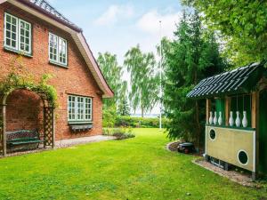 una casa con un patio con un invernadero y jarrones en 7 person holiday home in Krus, en Kruså