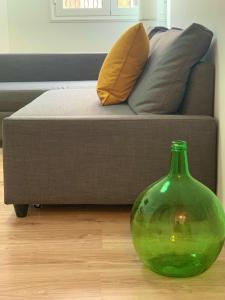 a green glass vase sitting on the floor next to a couch at Apartamento El Malecón in Santa Cruz de la Palma