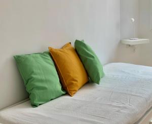 two green and yellow pillows sitting on a bed at Apartamento El Malecón in Santa Cruz de la Palma