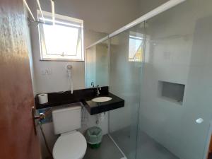 
a bathroom with a toilet, sink, and shower at Pousada Casa na Praia in Ubatuba
