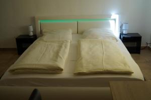 a bed with white sheets and pillows on it at La Fontana in Langelsheim