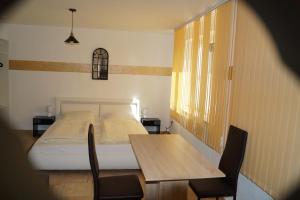 a bedroom with a bed and a table and chairs at La Fontana in Langelsheim
