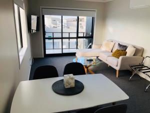 a living room with a table and a couch at Central Stadium Apartments in Hamilton