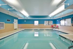 uma piscina com paredes azuis e tectos azuis em Holiday Inn Express - Evansville, an IHG Hotel em Evansville