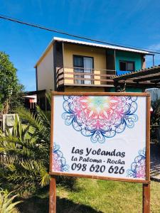 una señal frente a una casa con un edificio en Las yolandas, en La Paloma