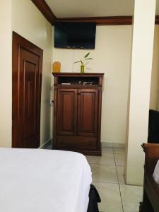 1 dormitorio con 1 cama y armario de madera en Hotel Fika Guayaquil en Guayaquil