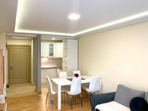 ein Wohnzimmer mit einem weißen Tisch und Stühlen in der Unterkunft Apartman La Promenade Zlatibor in Zlatibor