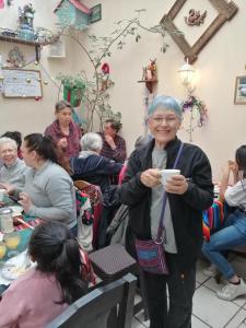 a woman holding a cup in a room full of people at Hotel Chalet in Chichicastenango