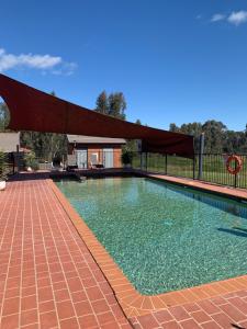 a large swimming pool with a canopy over it at Blazing Stump Motel & Suites in Wodonga