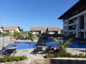 a resort with a swimming pool and a building at Flat Praia do Cupê - Porto de Galinhas in Porto De Galinhas