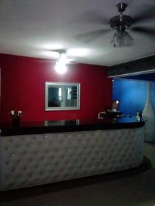 um bar num quarto com uma parede vermelha em Hotel Maracas Punta Cana em Punta Cana