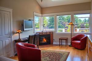 sala de estar con chimenea y TV en Birds of a Feather Victoria Oceanfront Studio Suites, en Colwood