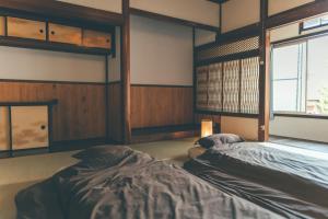 een kamer met 2 bedden en een raam erin bij ゲストハウス 宰嘉庵 かなで GuestHouse Saikaan KANADE in Maizuru