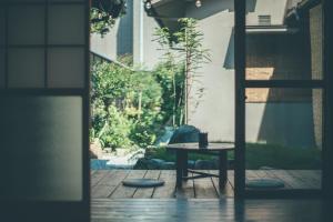 een tafel met een kopje op een patio bij ゲストハウス 宰嘉庵 かなで GuestHouse Saikaan KANADE in Maizuru