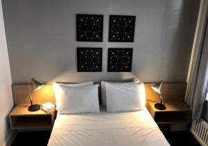 a bed with two pillows and a lamp at Touchstone Hotel - City Center in San Francisco