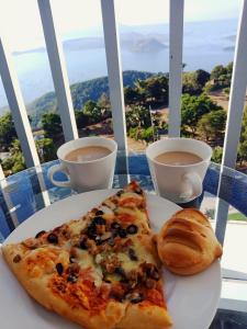 a plate with two slices of pizza and a cup of coffee at Bella Suites at Wind Residences Tagaytay in Tagaytay