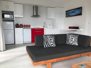 a living room with a couch with zebra pillows on it at Sea La Vie - Waiheke Island Luxury Accommodation in Onetangi