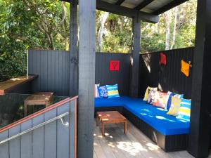 a blue bench on a pergola on a deck at Sea La Vie - Waiheke Island Luxury Accommodation in Onetangi