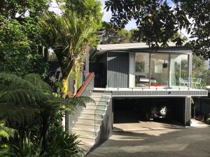 a house with a staircase leading to the front of it at Sea La Vie - Waiheke Island Luxury Accommodation in Onetangi