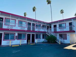 un bâtiment rouge et blanc avec un parking dans l'établissement Casa Valentine Inn - Los Angeles, à Los Angeles