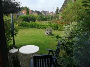 a table and chairs in a garden with a lawn at Wohnung "Orther Hafen" in Bannesdorf auf Fehmarn in Fehmarn