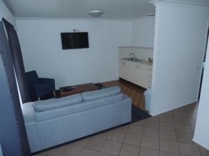 a living room with a couch and a chair at Argyle Terrace Motor Inn in Batemans Bay