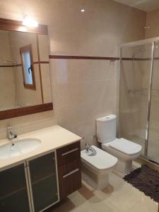 a bathroom with a toilet and a sink and a shower at Casa de Xerta in Xerta