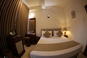 a hotel room with a bed and a window at The Royal Mall in Kandy