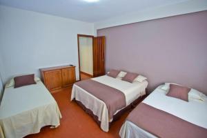 Habitación de hotel con 2 camas y espejo en Alecrin Apart en Puerto Iguazú
