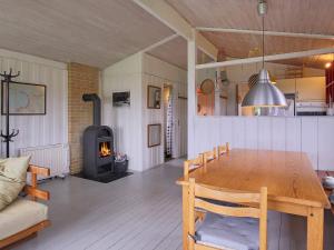 a living room with a wooden table and a wood stove at Seaside Serenity at Lumsas Retreat-By Traum in Ebbeløkke +13 photos