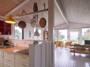 a kitchen with a counter and a dining room with a table at Seaside Serenity at Lumsas Retreat-By Traum in Ebbeløkke
