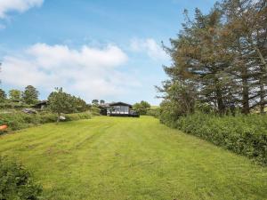 a large grass field with a house in the background at Seaside Serenity at Lumsas Retreat-By Traum in Ebbeløkke