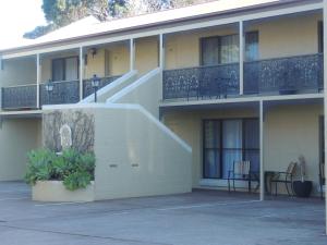 a building with a staircase on the side of it at Argyle Terrace Motor Inn in Batemans Bay