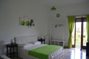 Un dormitorio con una cama con una manta verde. en Sorrento Experience, en Sorrento