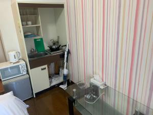 Pokój z łóżkiem i blatem z kuchenką mikrofalową w obiekcie Exsaison Shirokita 511 w Osace