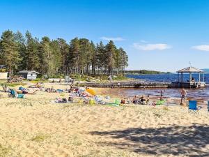 un groupe de personnes sur une plage près de l'eau dans l'établissement 11 person holiday home in Osen, à Vika